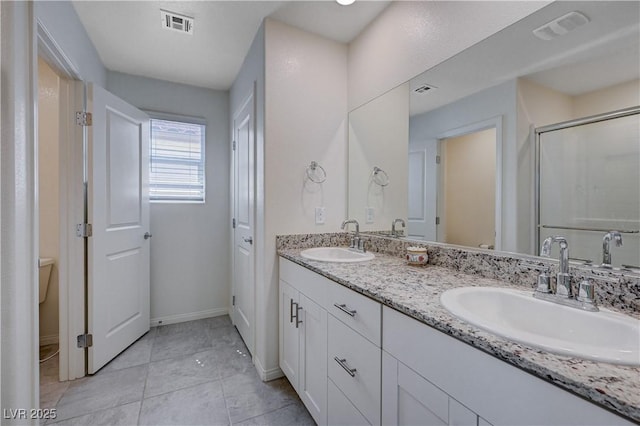 387 Larksong Ave, Henderson, NV 89011 - bathroom with double vanity, an enclosed shower, tile patterned floors, and baseboards