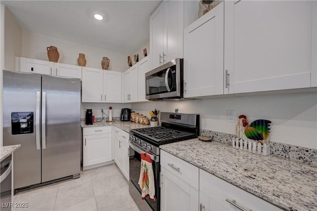 387 Larksong Ave, Henderson, NV 89011 - kitchen featuring appliances with stainless steel finishes, white cabinets, light stone countertops, light tile patterned floors, and recessed lighting