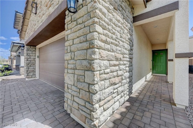 387 Larksong Ave, Henderson, NV 89011 - view of exterior entry featuring driveway, stucco siding, an attached garage, and stone siding