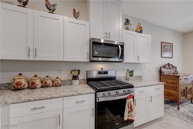 387 Larksong Ave, Henderson, NV 89011 - kitchen with stainless steel appliances, white cabinets, and light stone countertops