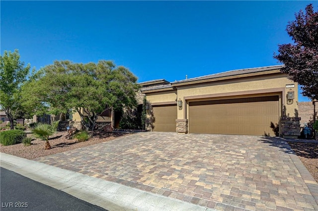 view of front facade featuring stucco siding, decorative driveway, a tile roof, stone siding, and a garage