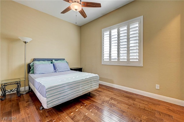 bedroom with baseboards, hardwood / wood-style floors, and ceiling fan