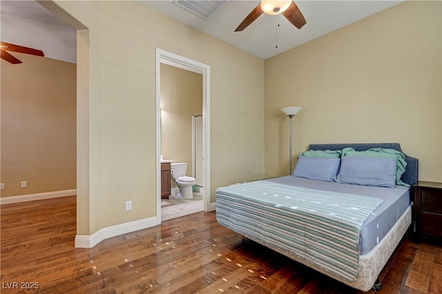 bedroom with wood finished floors, connected bathroom, baseboards, and a ceiling fan