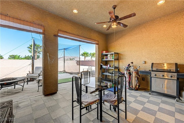 dining room featuring a ceiling fan, recessed lighting, and a textured wall