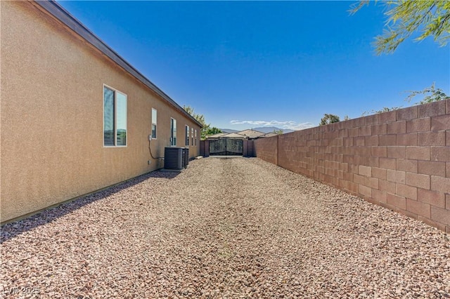 view of property exterior with a fenced backyard, stucco siding, and central air condition unit