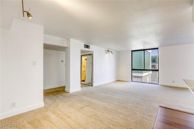 3930 University Center Dr Unit 311, Las Vegas, NV 89119 - unfurnished living room with carpet floors, baseboards, and expansive windows