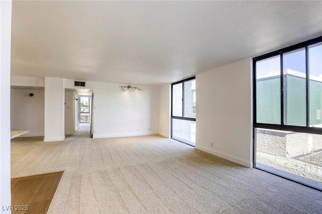 3930 University Center Dr Unit 311, Las Vegas, NV 89119 - empty room with light colored carpet, baseboards, and expansive windows