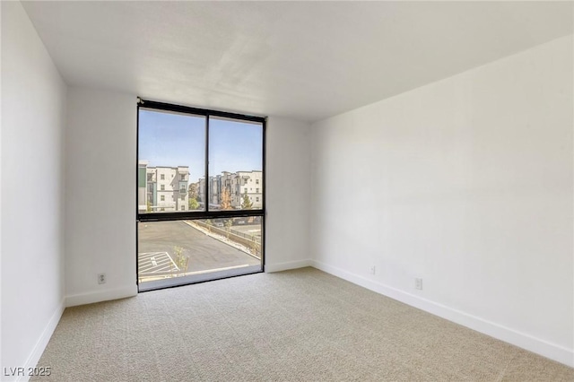 3930 University Center Dr Unit 311, Las Vegas, NV 89119 - unfurnished room with carpet floors, baseboards, and a wall of windows