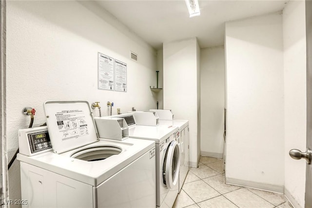 3930 University Center Dr Unit 312, Las Vegas, NV 89119 - shared laundry featuring independent washer and dryer, light tile patterned floors, and baseboards