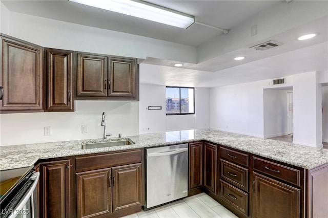 3930 University Center Dr Unit 312, Las Vegas, NV 89119 - kitchen with stainless steel appliances, a sink, a peninsula, light stone countertops, and dark brown cabinetry