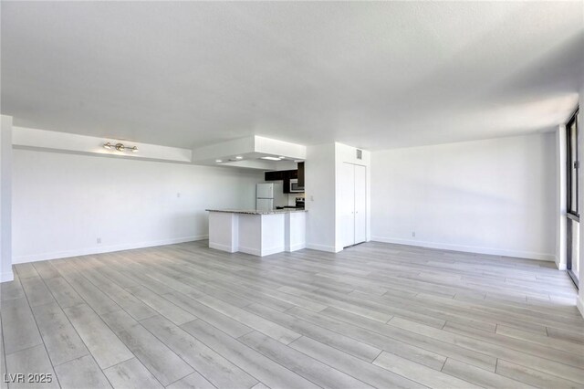 3930 University Center Dr Unit 312, Las Vegas, NV 89119 - unfurnished living room featuring light wood-type flooring and baseboards