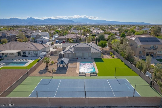 aerial view of residential area with a pool area and a mountain backdrop