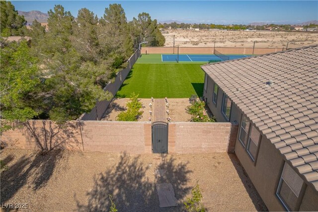 8228 Fulton Ranch St, Las Vegas, NV 89131 - fenced backyard featuring a tennis court, a gate, and a mountain view