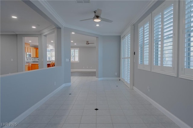 hall featuring crown molding, recessed lighting, baseboards, and light tile patterned floors