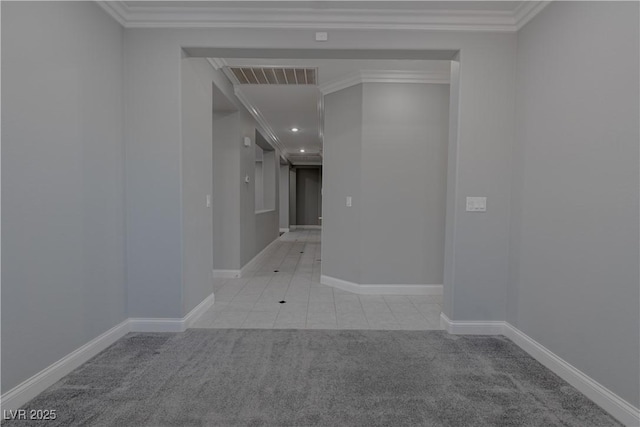 carpeted spare room with baseboards, ornamental molding, and tile patterned flooring