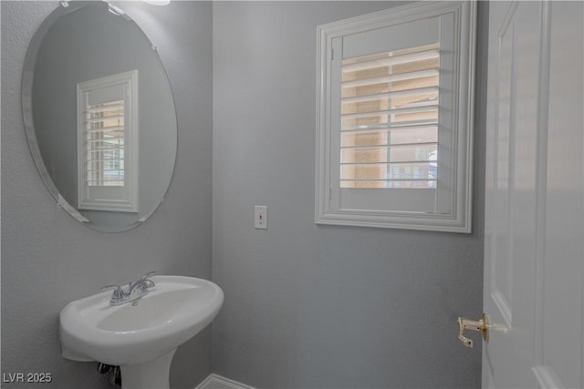 bathroom with a sink and baseboards