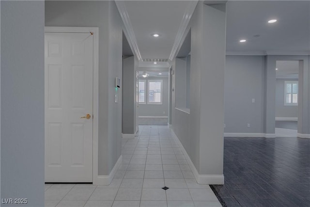 hall featuring healthy amount of natural light, baseboards, ornamental molding, and recessed lighting