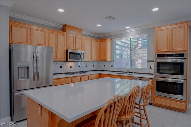 8228 Fulton Ranch St, Las Vegas, NV 89131 - kitchen featuring appliances with stainless steel finishes, light brown cabinets, crown molding, tasteful backsplash, and a kitchen island