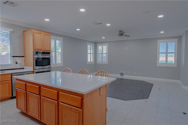 kitchen featuring crown molding, stainless steel appliances, recessed lighting, a ceiling fan, and a kitchen island