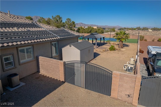8228 Fulton Ranch St, Las Vegas, NV 89131 - view of side of property with a gate, a mountain view, a shed, and a gazebo