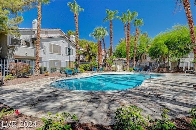 community pool featuring fence and a patio