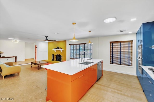 1679 Raindance Way, Las Vegas, NV 89169 - kitchen featuring a sink, a fireplace, stainless steel appliances, ceiling fan, and light countertops