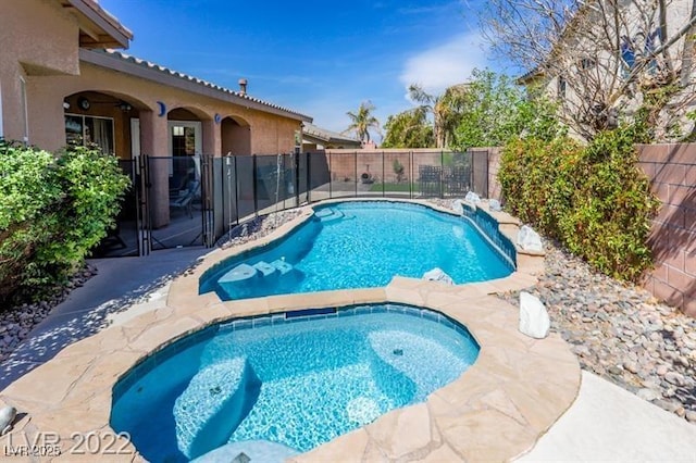 view of swimming pool featuring an in-ground hot tub and a fenced backyard