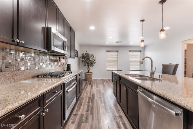 4650 Ranch House Rd Unit 86, North Las Vegas, NV 89031 - kitchen featuring stainless steel appliances, a sink, light wood-type flooring, light stone counters, and recessed lighting