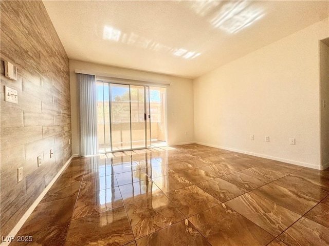 unfurnished room with marble tiled floors and baseboards