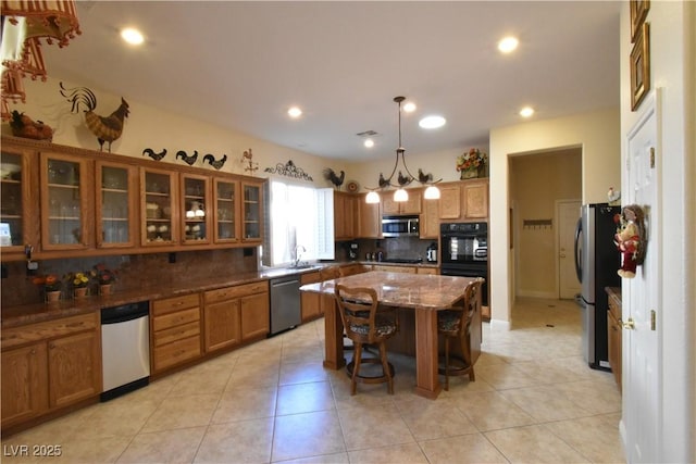 7325 Rustic Crest St, Las Vegas, NV 89149 - kitchen featuring black appliances, brown cabinets, tasteful backsplash, a sink, and a kitchen island