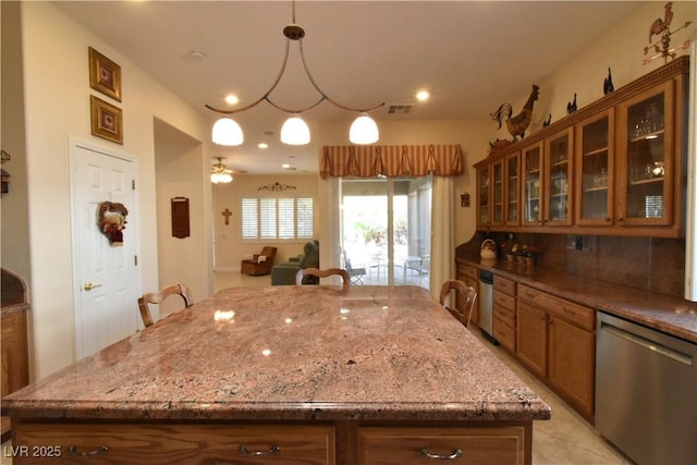 7325 Rustic Crest St, Las Vegas, NV 89149 - kitchen with stainless steel dishwasher, brown cabinets, light stone countertops, glass insert cabinets, and a center island