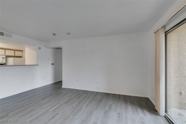 2300 E Silverado Ranch Blvd Unit 1070, Las Vegas, NV 89183 - unfurnished living room with wood finished floors, healthy amount of natural light, and baseboards