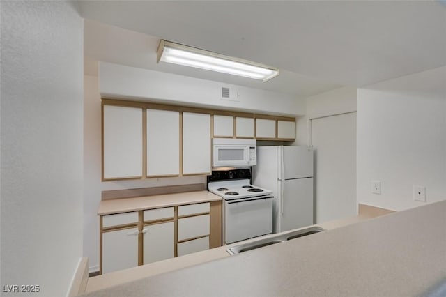 2300 E Silverado Ranch Blvd Unit 1070, Las Vegas, NV 89183 - kitchen featuring white appliances, a sink, white cabinetry, and light countertops