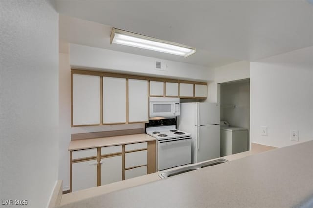 2300 E Silverado Ranch Blvd Unit 1070, Las Vegas, NV 89183 - kitchen featuring white appliances, washer / dryer, a sink, white cabinets, and light countertops