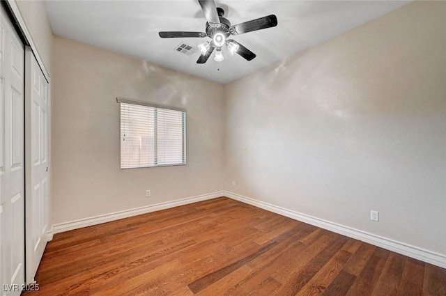 unfurnished bedroom with wood finished floors, a closet, and baseboards