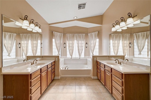 full bath featuring two vanities, a garden tub, and tile patterned flooring