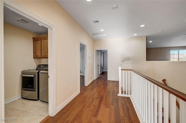 hall with an upstairs landing, baseboards, recessed lighting, light wood finished floors, and separate washer and dryer