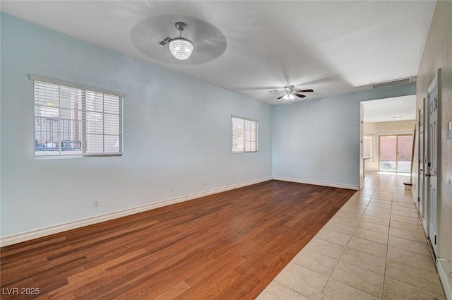 spare room featuring a ceiling fan, baseboards, and wood finished floors