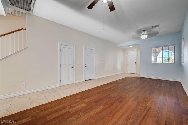 unfurnished living room with a ceiling fan, wood finished floors, and baseboards