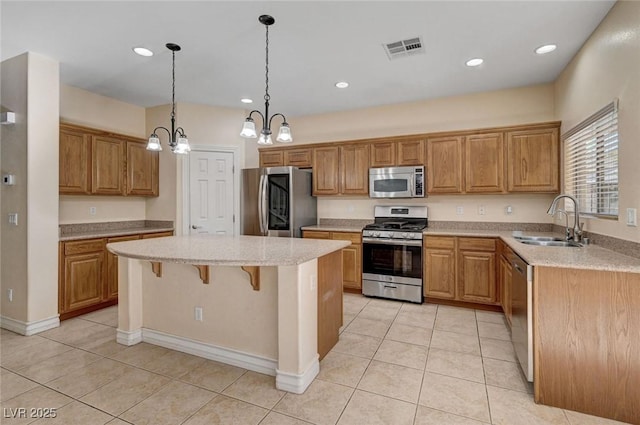 kitchen featuring stainless steel appliances, a sink, a kitchen island, a chandelier, and light tile patterned flooring