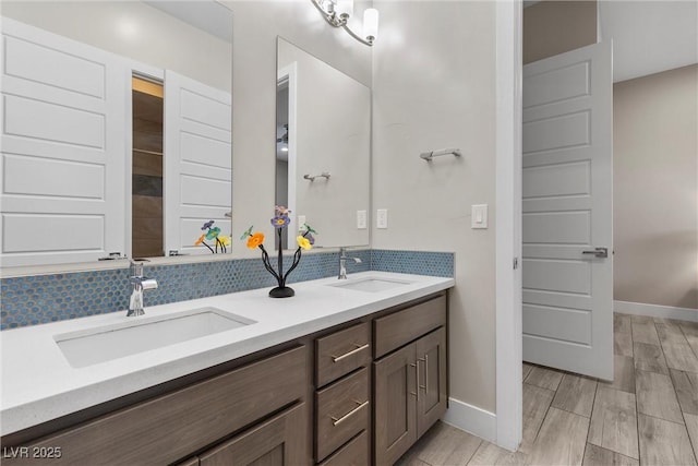 7477 Triple Knot Ct, Las Vegas, NV 89113 - full bathroom with double vanity, decorative backsplash, baseboards, and wood finished floors