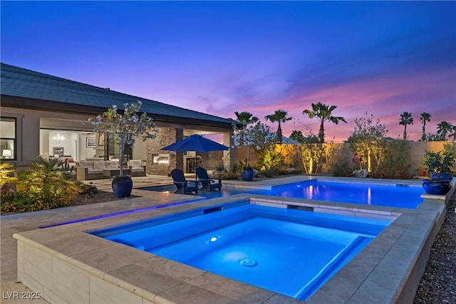 7477 Triple Knot Ct, Las Vegas, NV 89113 - pool at dusk featuring an in-ground hot tub, outdoor lounge area, a fenced backyard, and a patio area