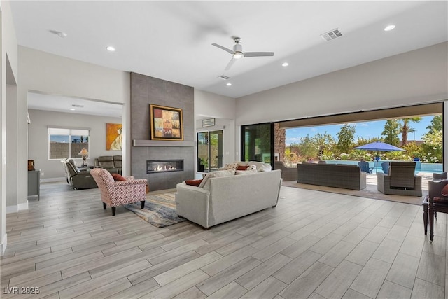 7477 Triple Knot Ct, Las Vegas, NV 89113 - living area featuring a tiled fireplace, light wood finished floors, ceiling fan, recessed lighting, and baseboards
