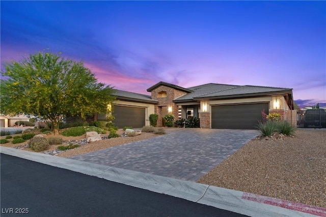 7477 Triple Knot Ct, Las Vegas, NV 89113 - view of front of house featuring a garage, stone siding, decorative driveway, a gate, and stucco siding