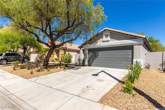 view of front of home with stucco siding, a tiled roof, driveway, and an attached garage