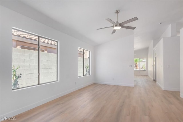 unfurnished room with lofted ceiling, ceiling fan, light wood-style floors, and baseboards