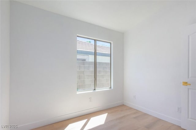 spare room with light wood-style floors and baseboards