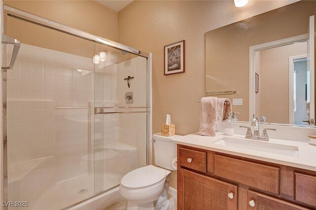 bathroom featuring a stall shower, toilet, and vanity