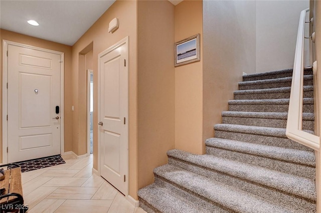 entryway with stairway, recessed lighting, and baseboards