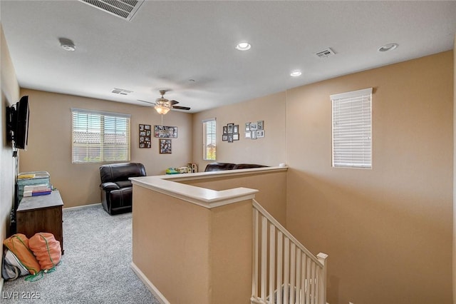 hallway featuring carpet floors, an upstairs landing, baseboards, and recessed lighting